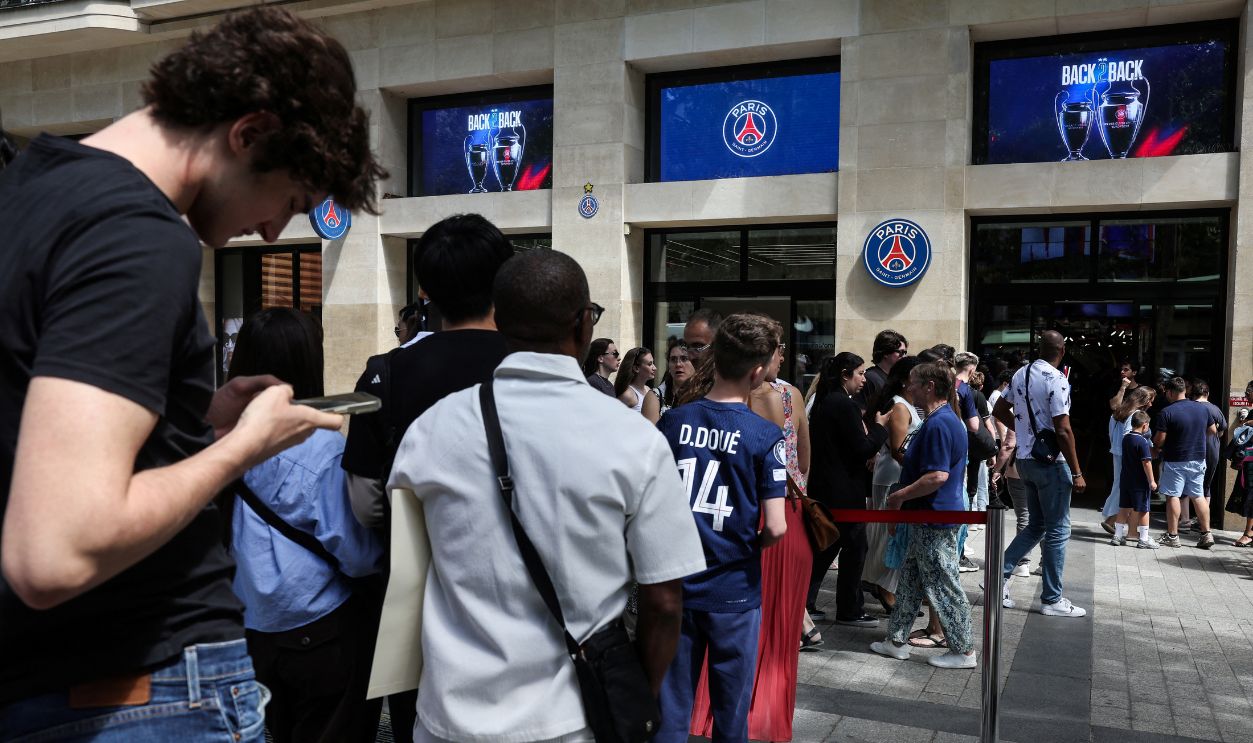 Paris Saint-Germain's supporters queue outside the PSG store on the Champs-Elysees avenue, central Paris on June 1, 2026 to buy the new PSG's jersey with two stars, two days after the team victory in the UEFA Champions League football final.