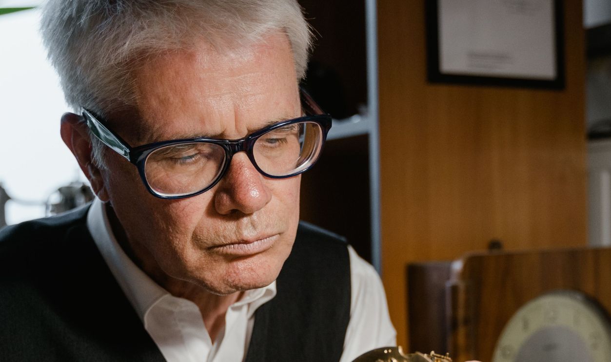 Senior watchmaker focuses on inspecting an intricate timepiece