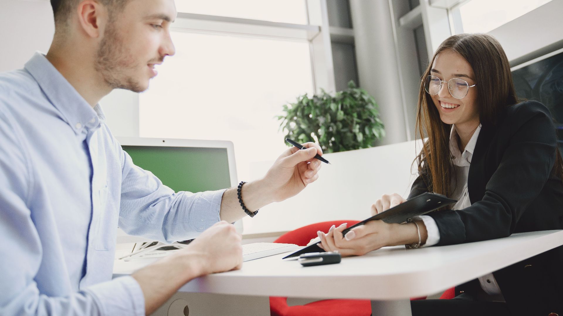 Man and woman discussing business at a bright modern office table.