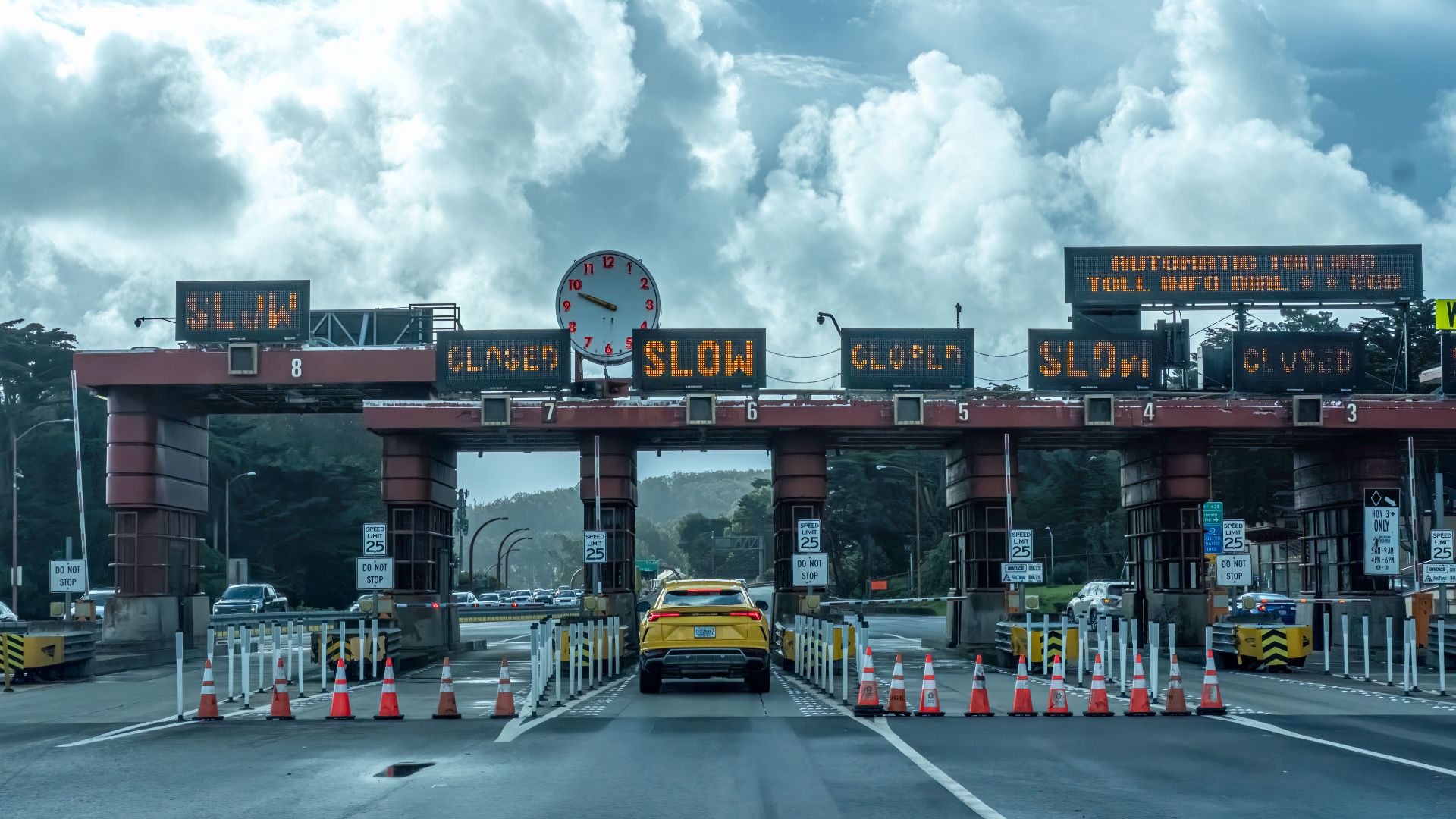 View of vehicles approaching the toll plaza at Golden Gate Bridge in San Francisco under a cloudy sky.