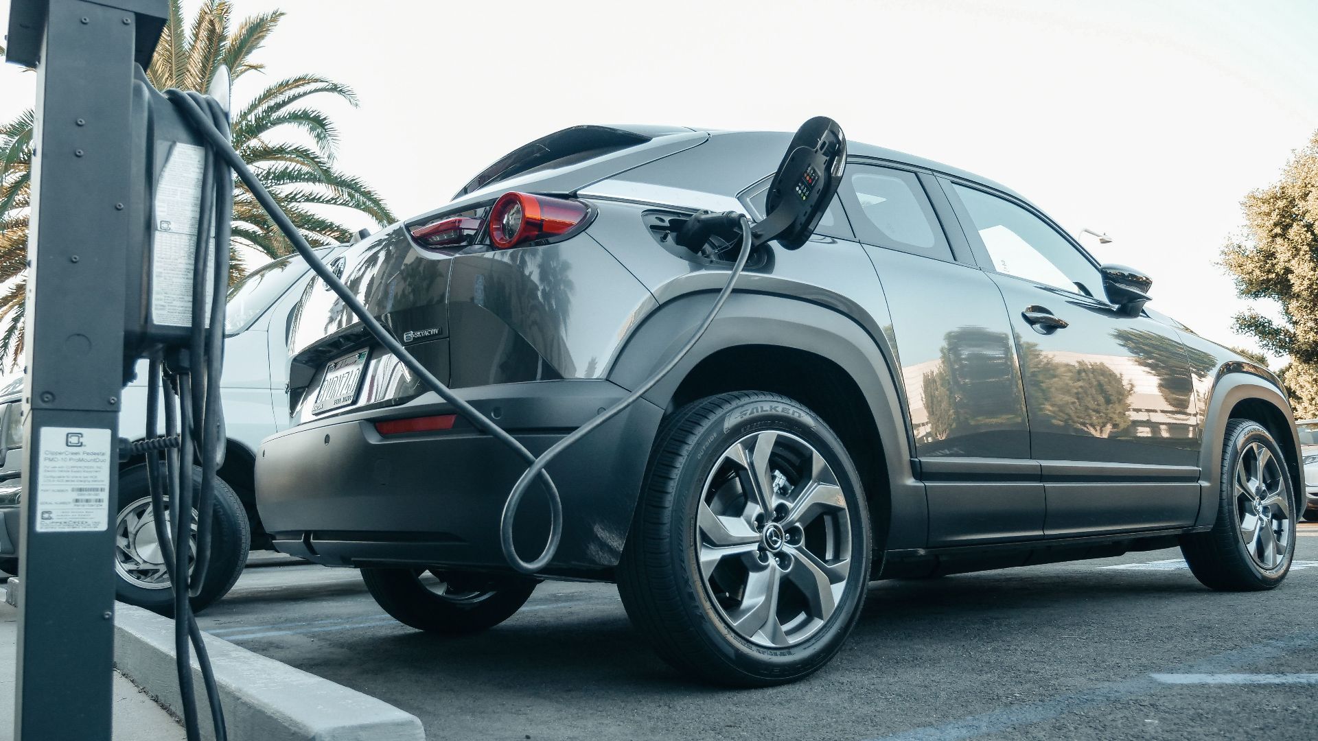 Modern electric vehicle charging at an outdoor station in daylight.