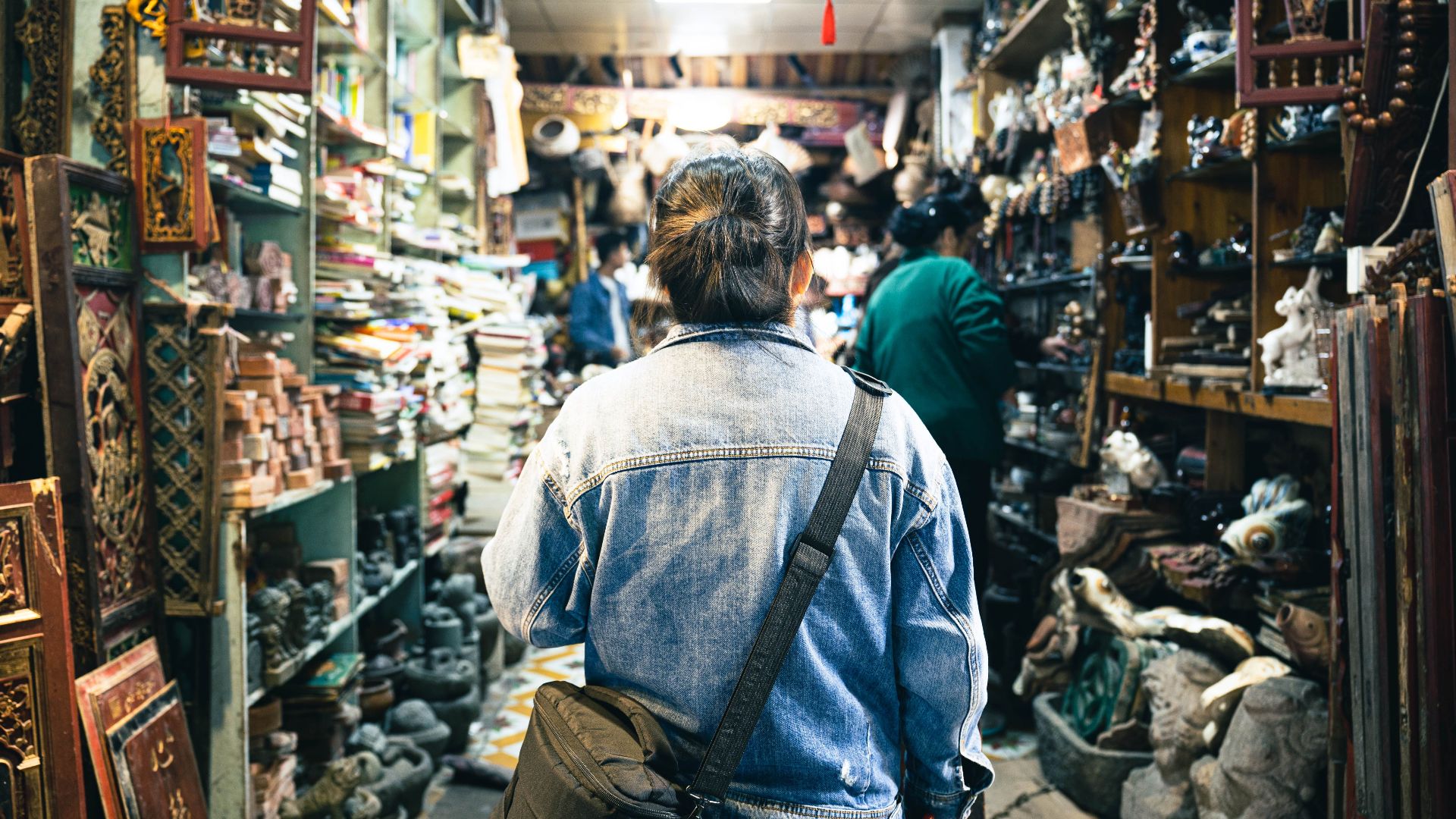 A person browsing through a bustling antique store filled with vintage treasures and cultural artifacts.