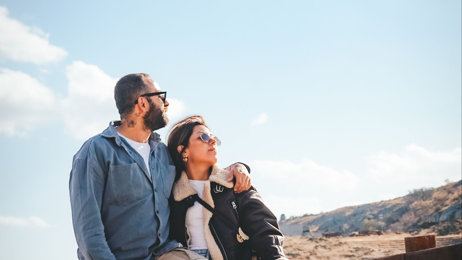 A couple standing closely together on a pier, enjoying a serene view. Perfect for travel and romance themes.