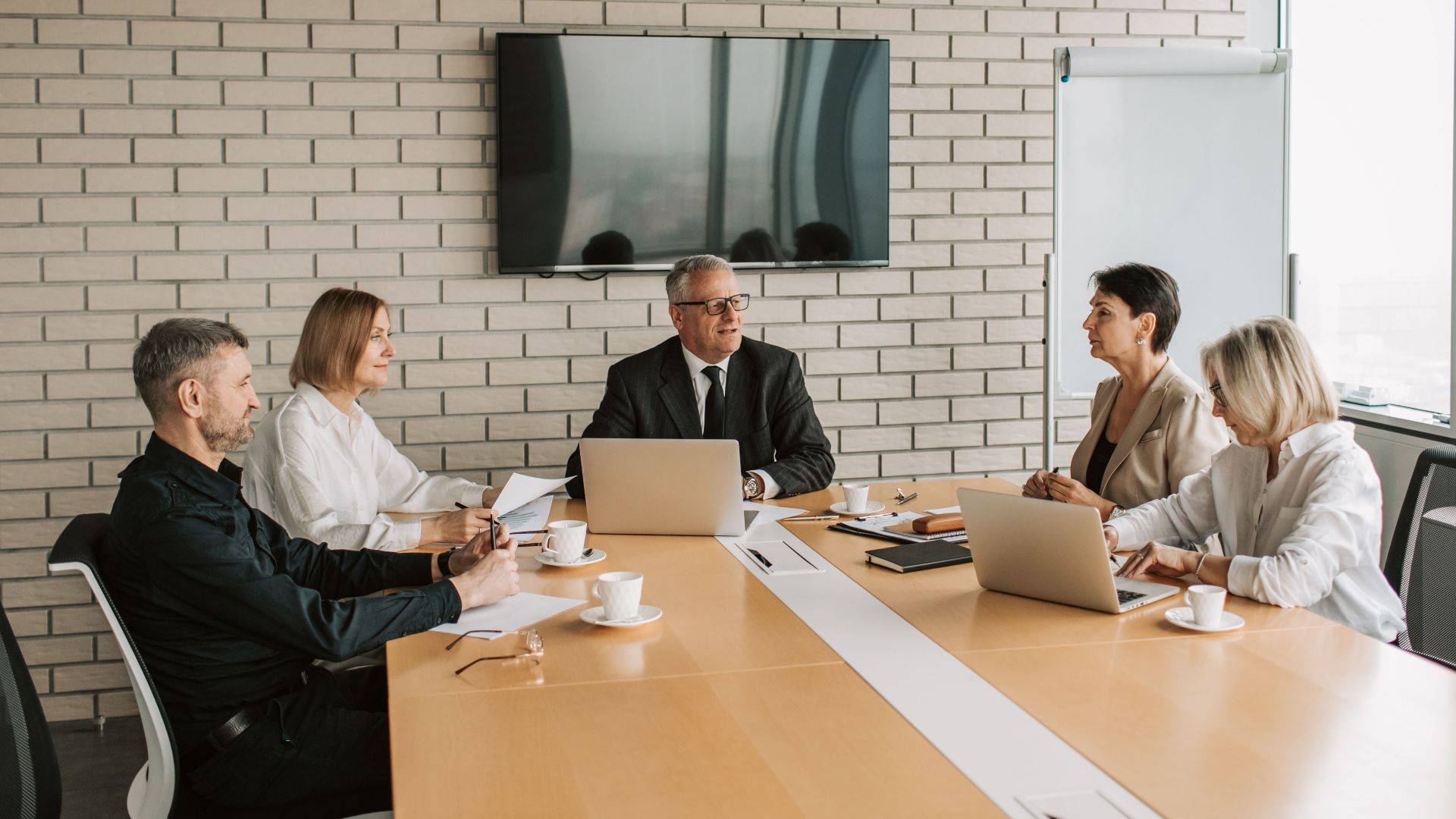 A professional team meeting with laptops and documents in a modern office.