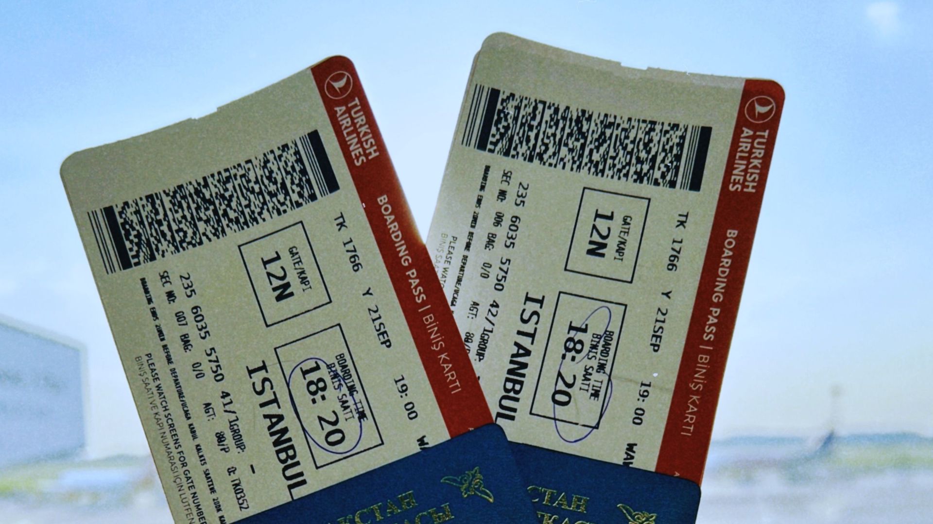 A Kazakhstan passport holds two airline tickets against an airport backdrop in Warsaw, Poland.