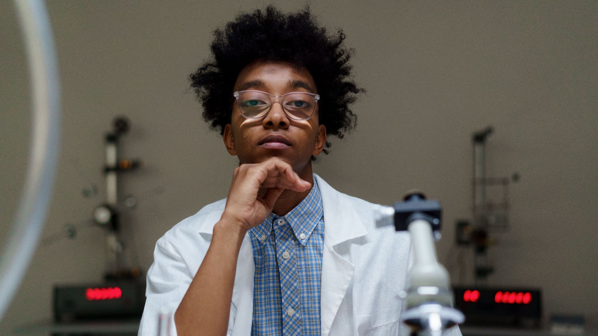 Portrait of a thoughtful scientist with eyeglasses in a laboratory setting.