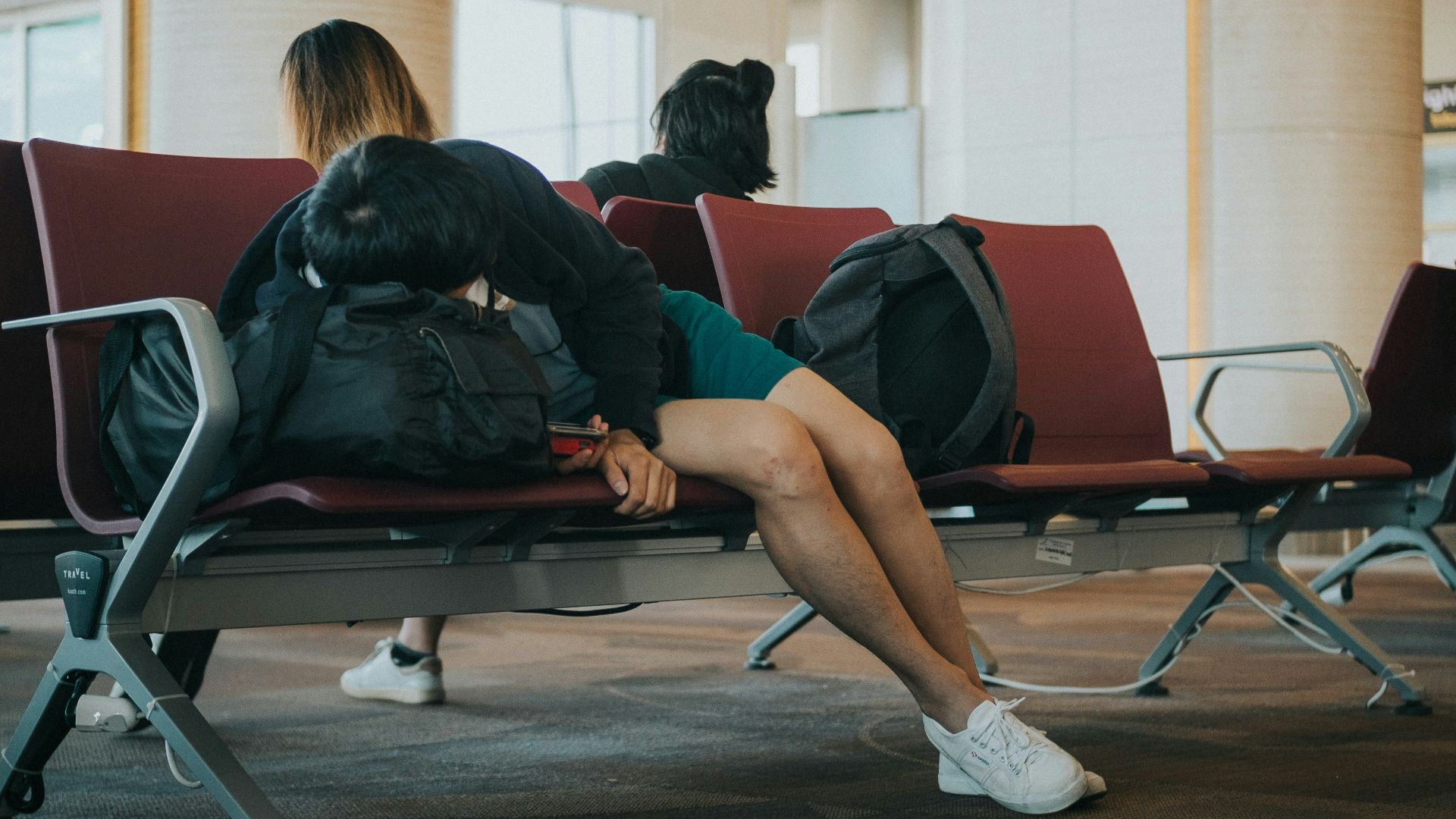 unknown person lying on brown bench indoors
