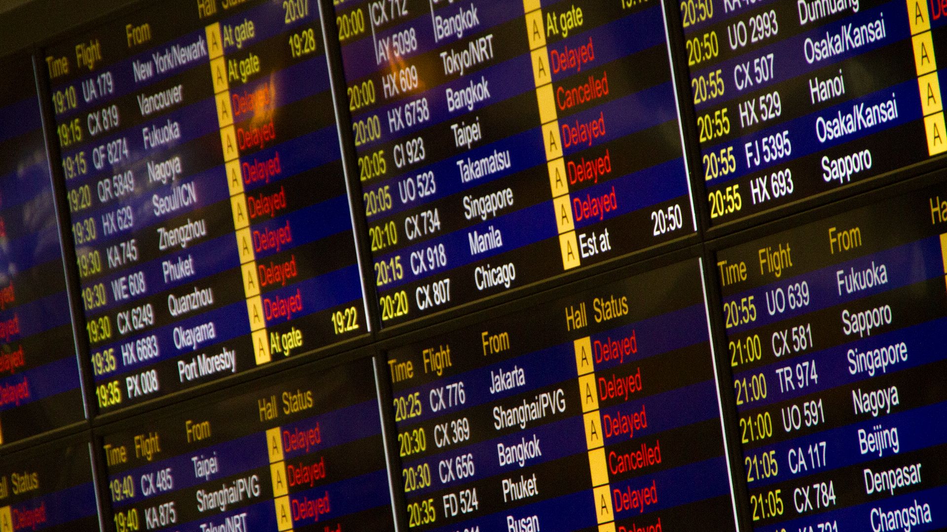 Close-up of digital flight information board showing arrivals and departures at an airport.