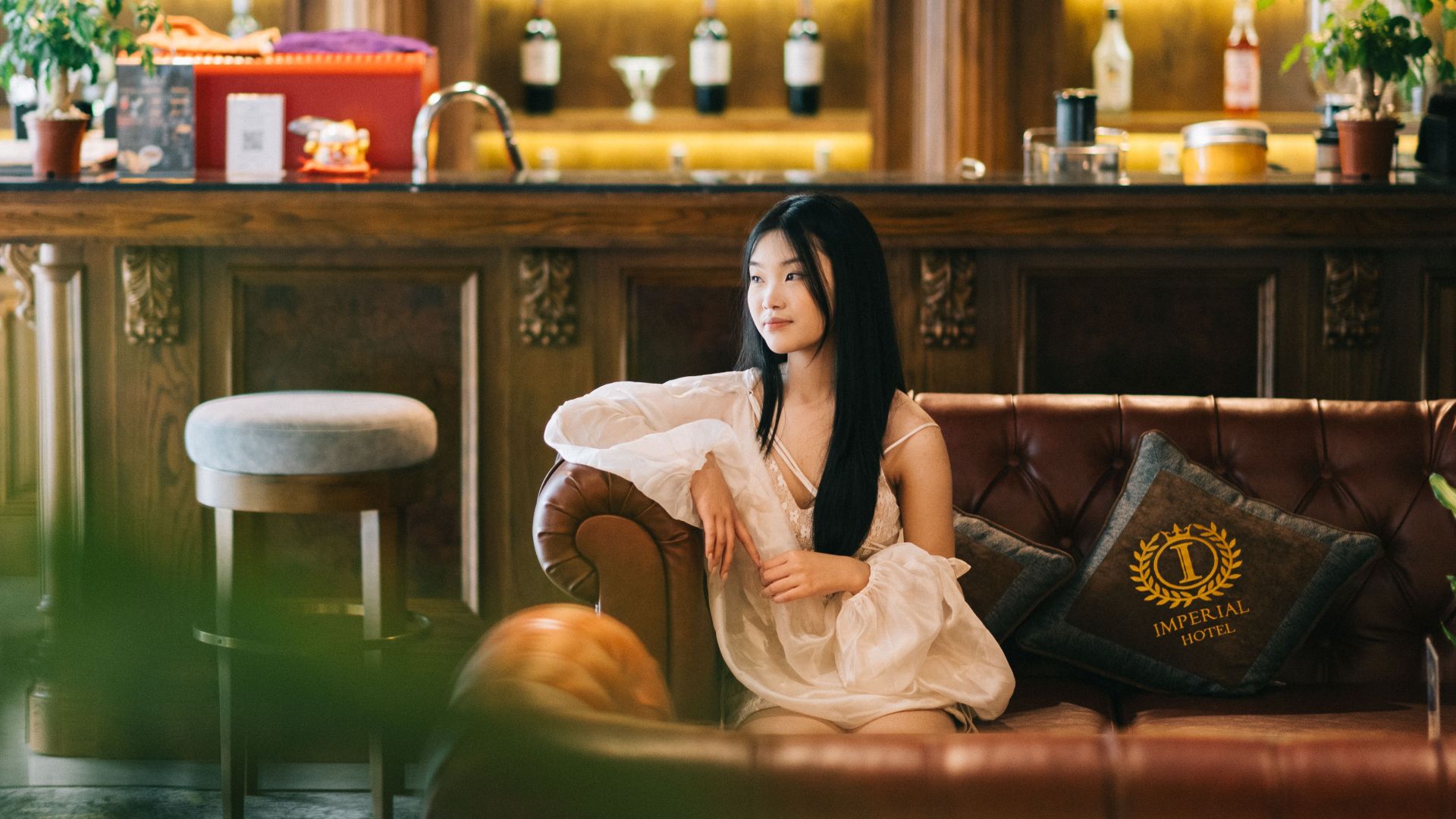 East Asian woman seated on a couch in a luxurious hotel lounge in Lạng Sơn, Vietnam.