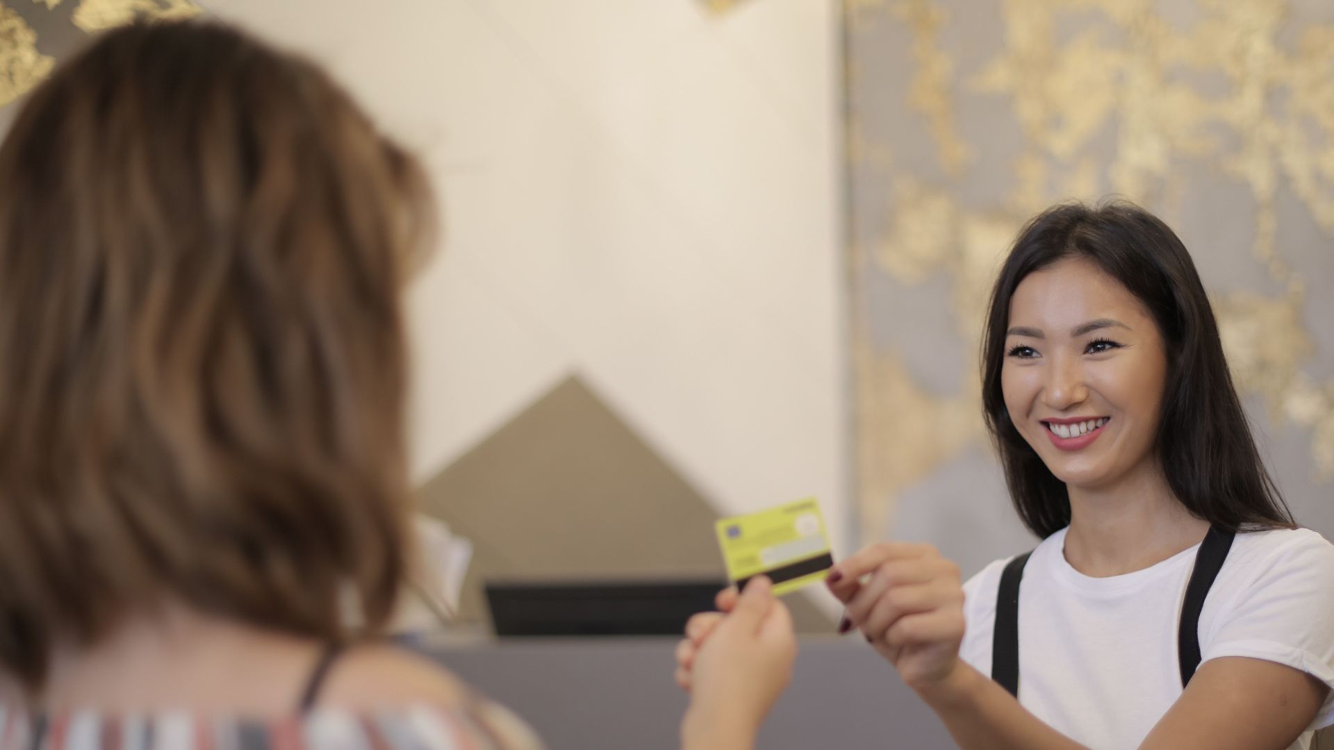 Florist smiling while accepting payment in a flower shop.
