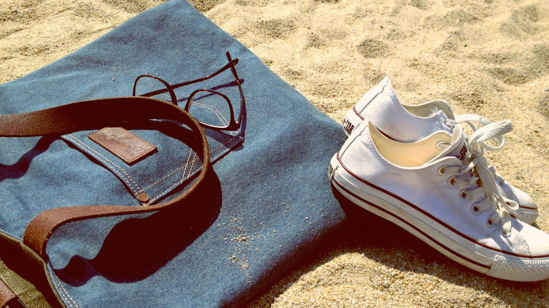 pair of white low-top sneakers on brown sand