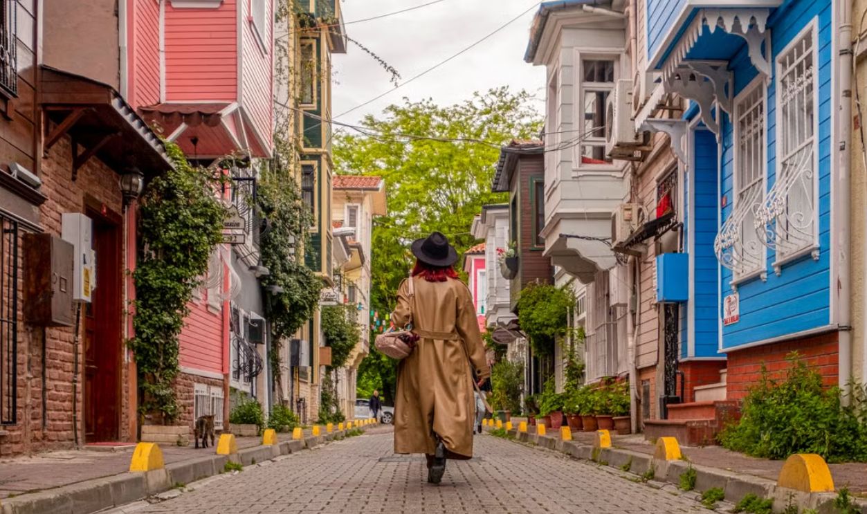 Stylish woman walks down a colorful street in Istanbul, showcasing urban elegance