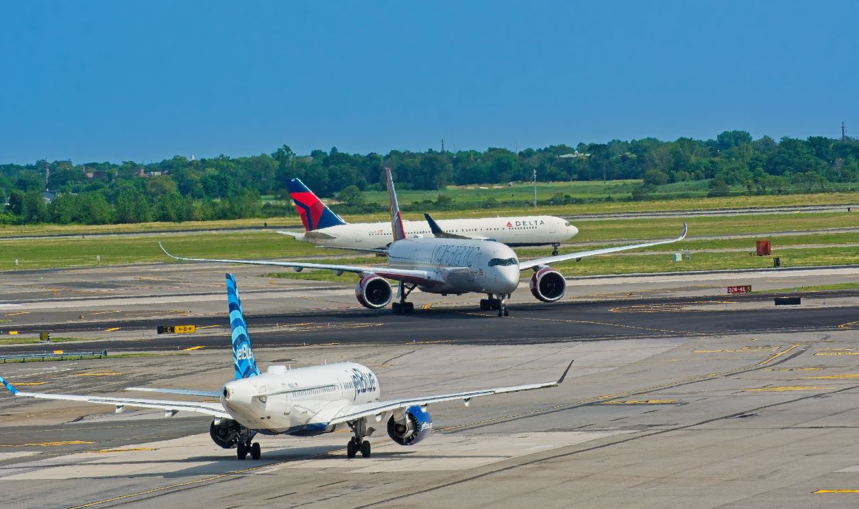 Airplanes from various airlines taxiing on a JFK airport runway in New York