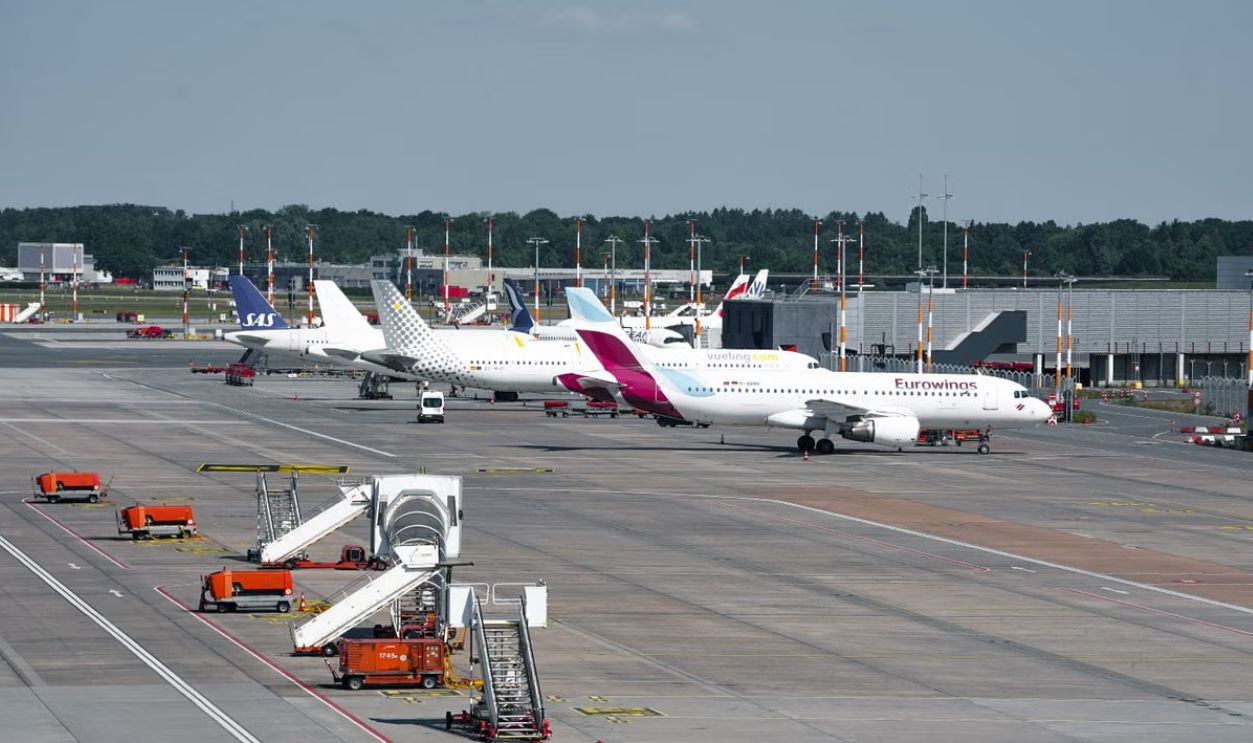 A busy scene at Hamburg Airport with various planes parked at the terminal during the day