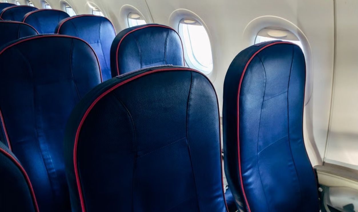 Close-up of empty airplane seats with windows showing daylight. Ideal for travel themes.