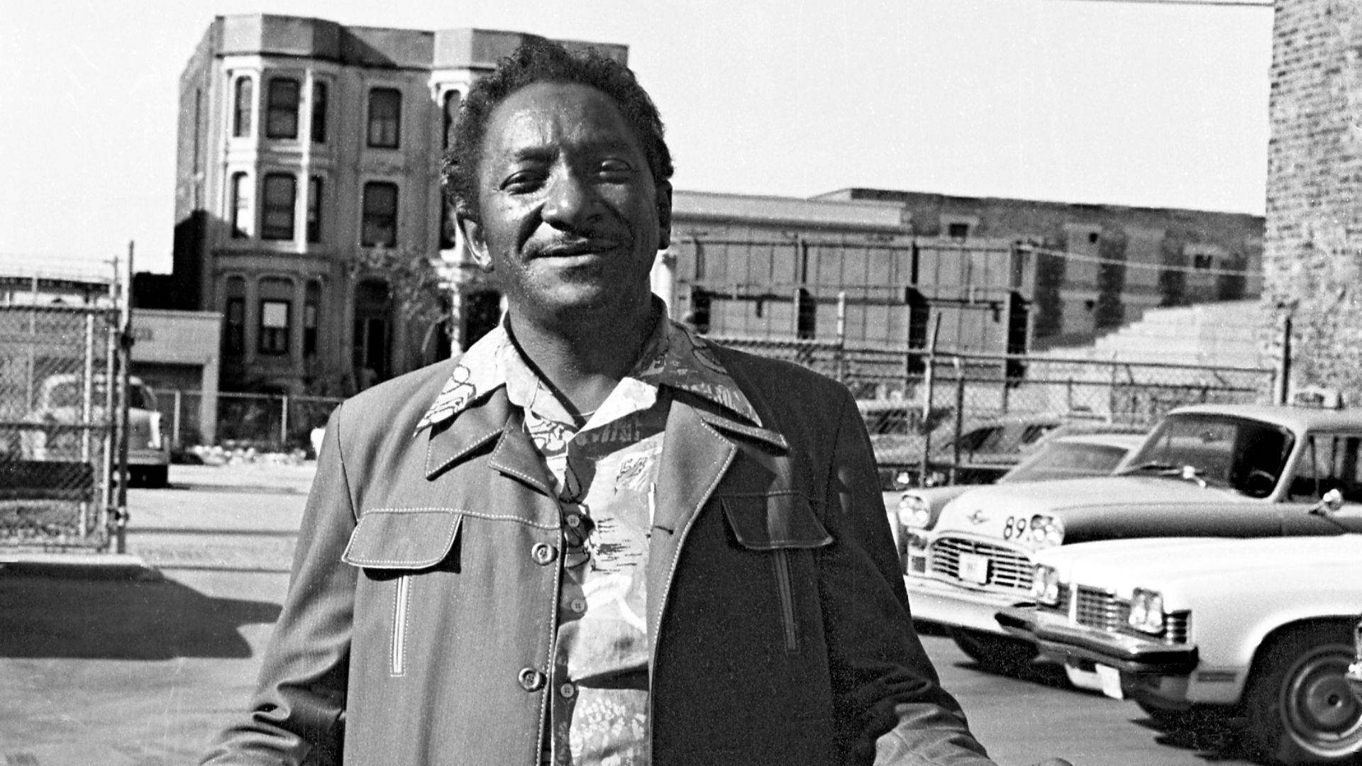 Man in leisure suit in parking lot, approximately Prairie Avenue District, Chicago, 1978. Selling watches?