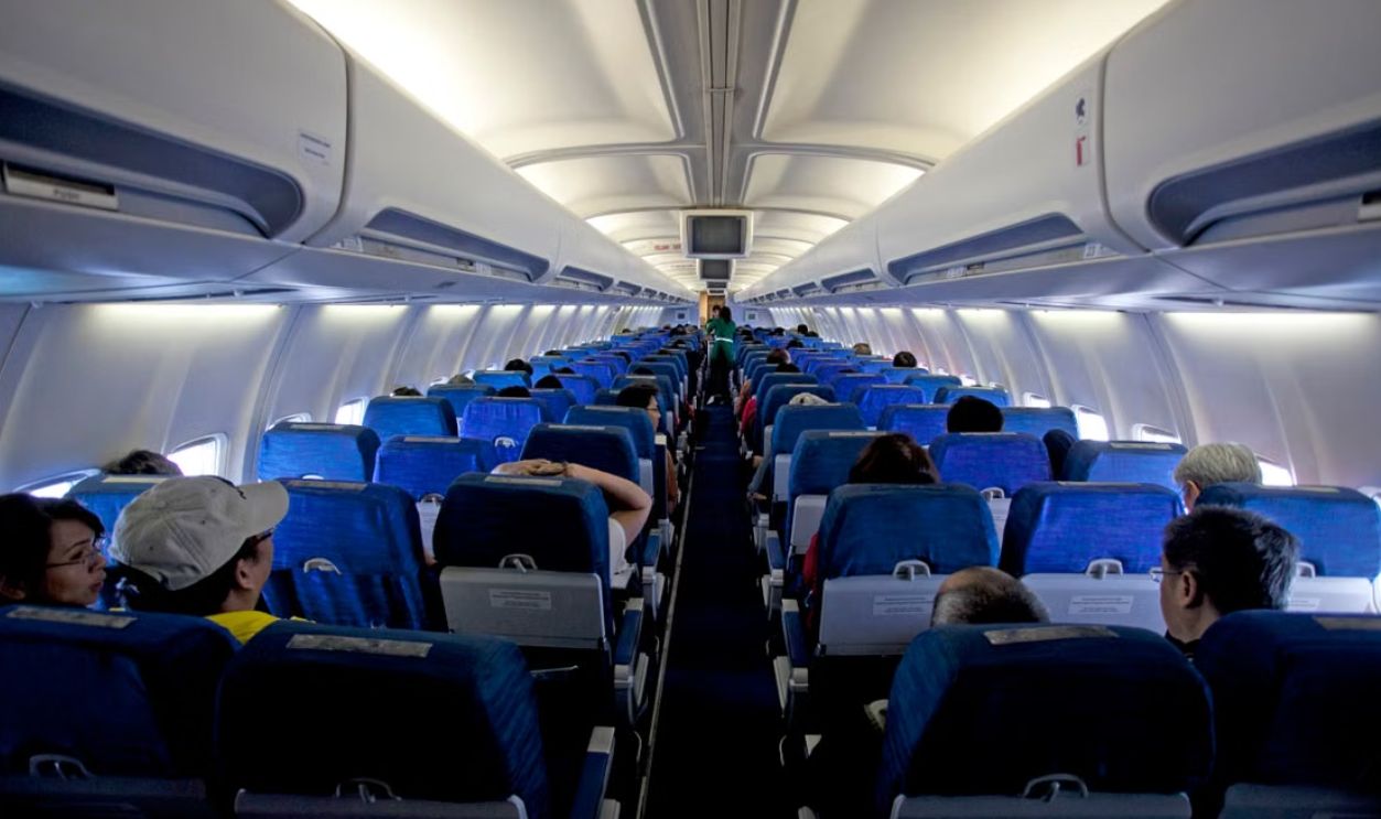 Symmetrical view of passengers inside a commercial airplane cabin during daytime travel