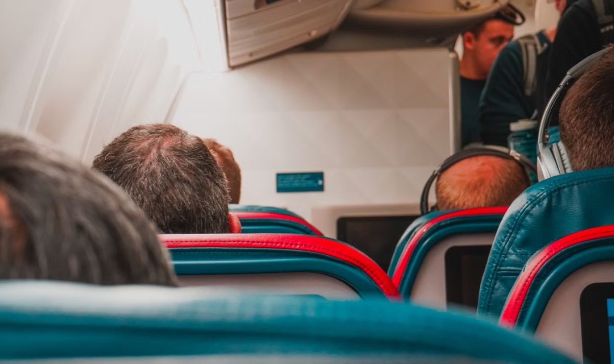 Interior view of an airplane cabin with passengers seated, focusing on seats and layout