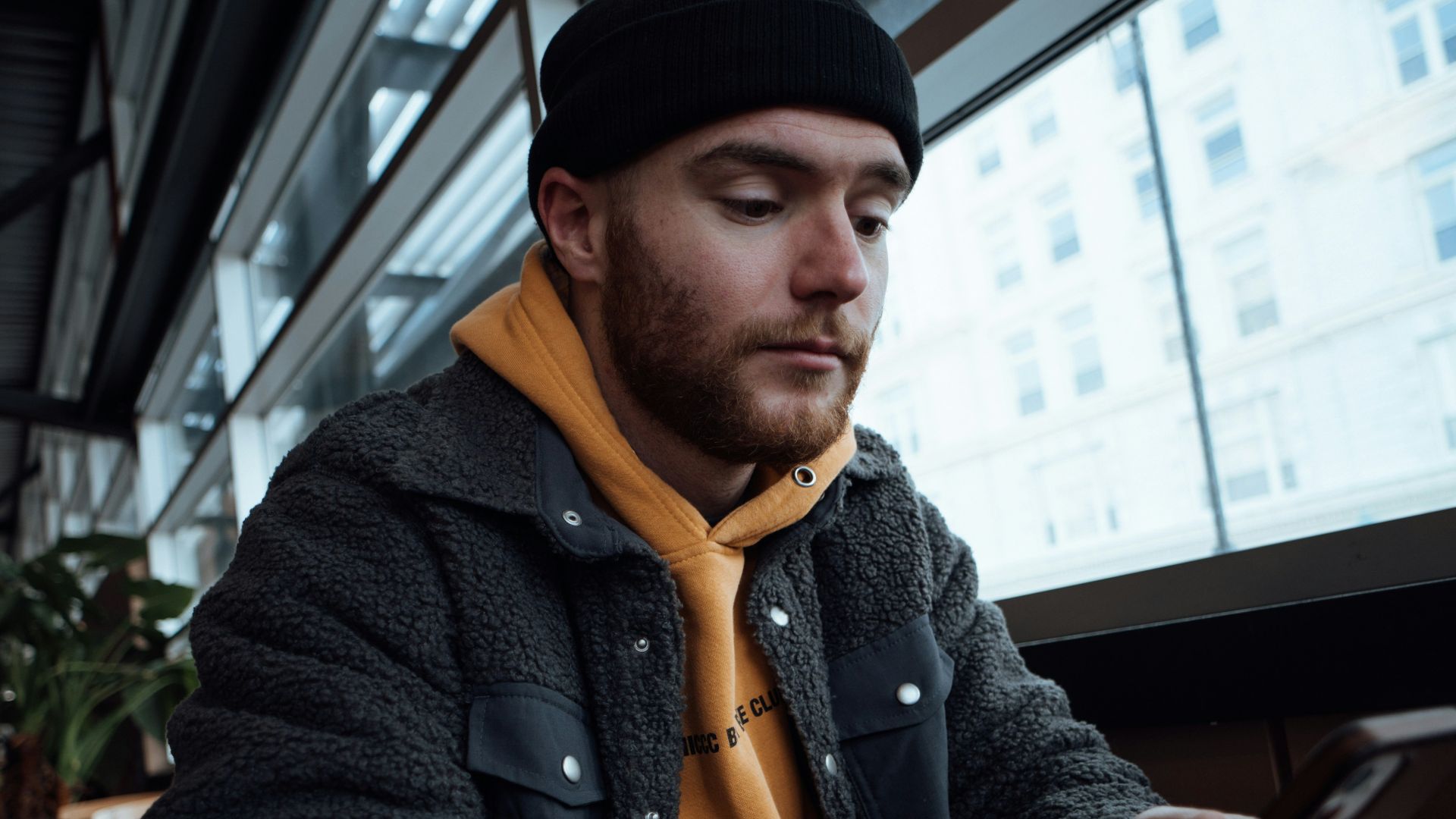 a man sitting at a table looking at his cell phone