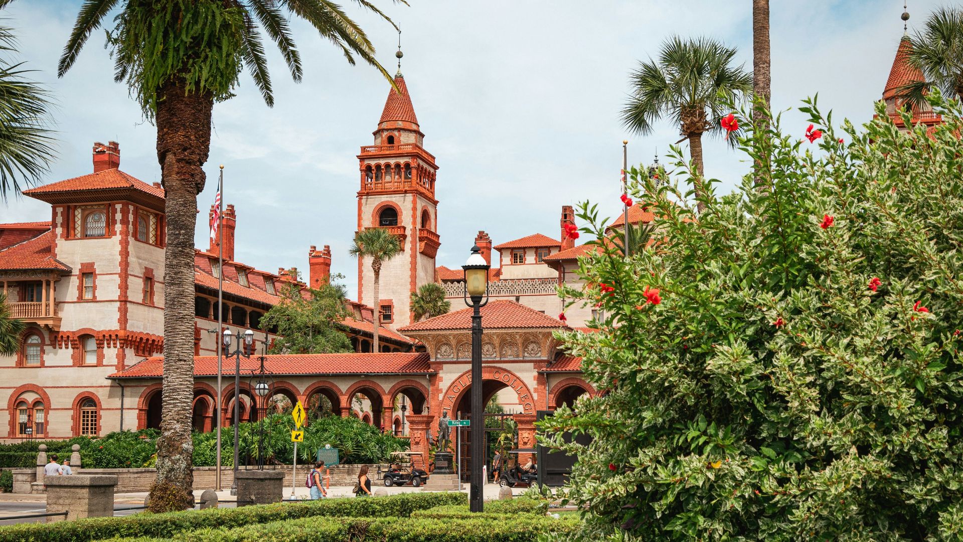 A large building with a clock tower next to a lush green park