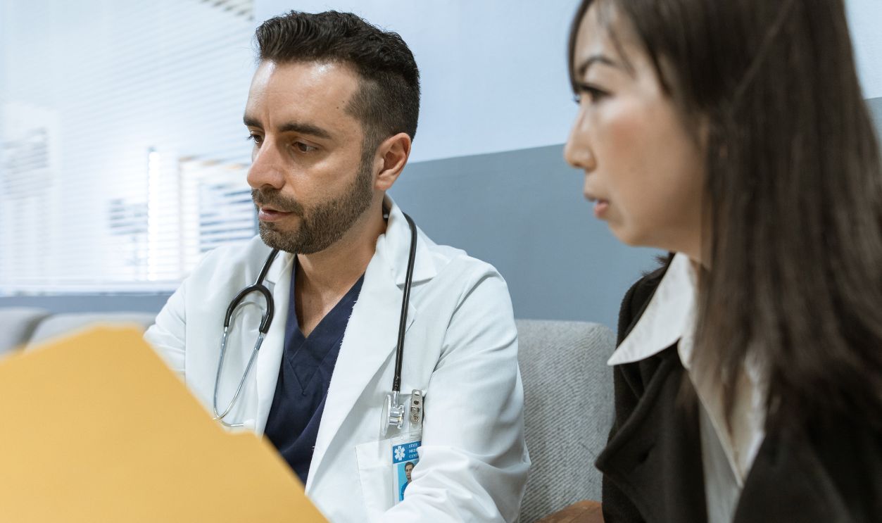 Doctor discusses health records with a patient in a clinical setting