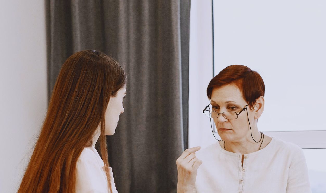 Two women indoors using sign language to communicate, depicting connection across generations