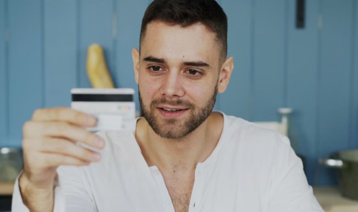 Man holding credit card and smartphone, shopping online at home