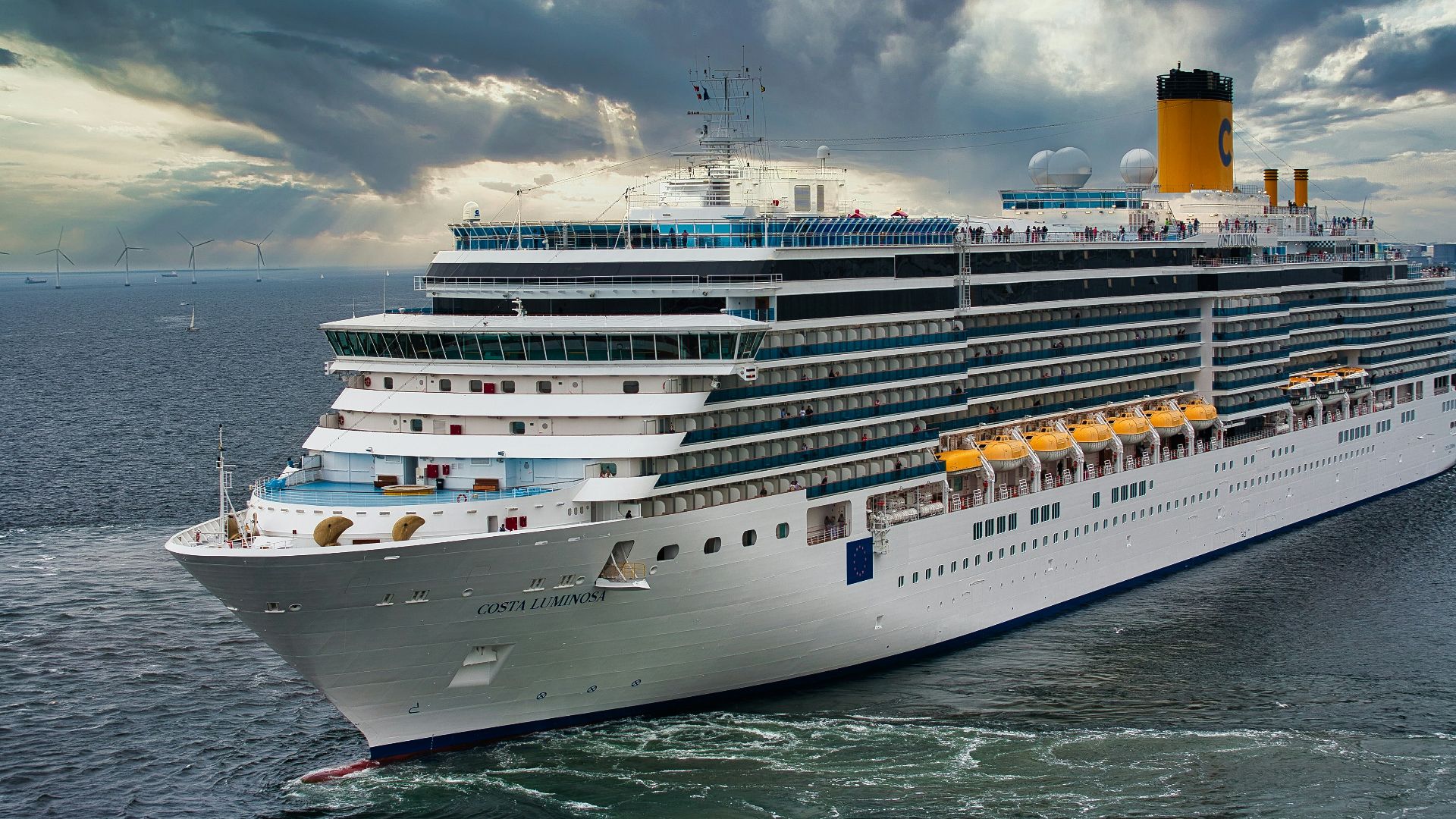 white cruise ship on sea under white clouds and blue sky during daytime