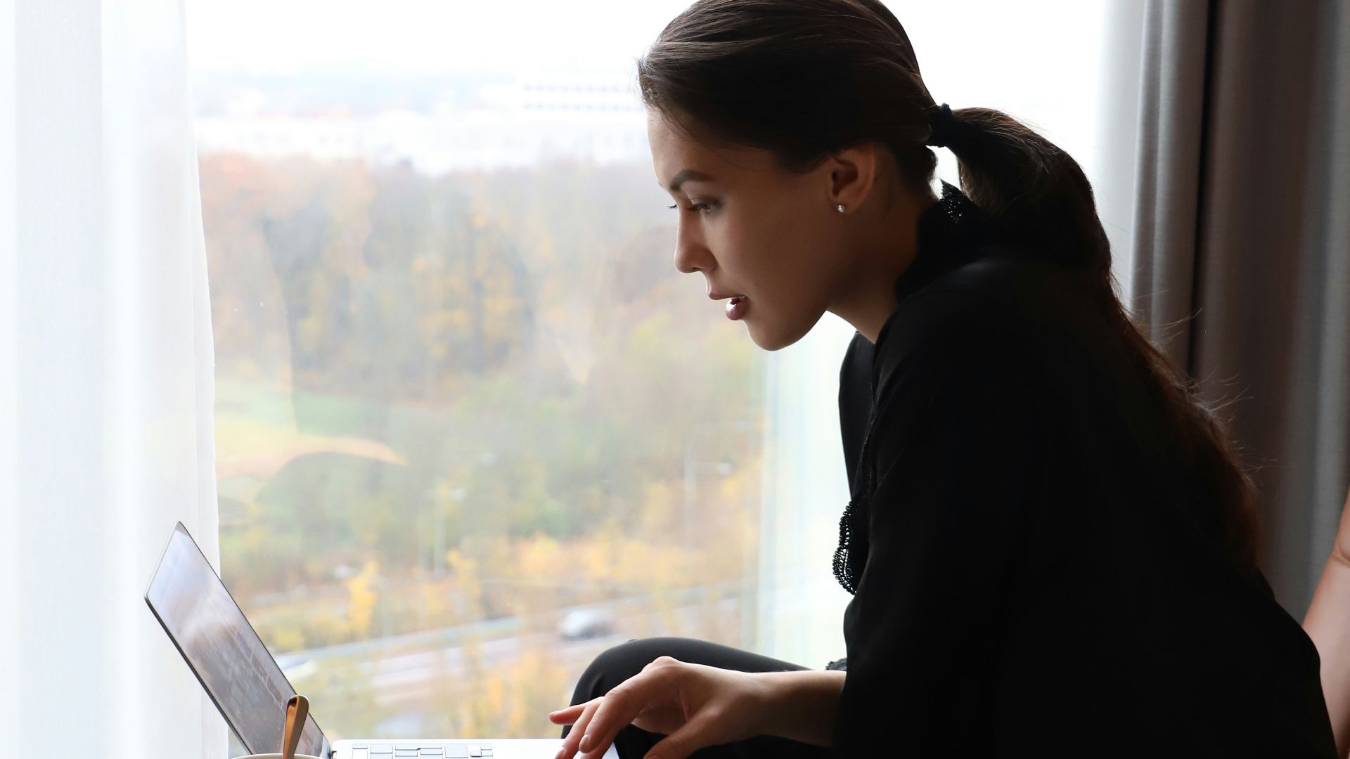 a woman sitting in a chair using a laptop computer