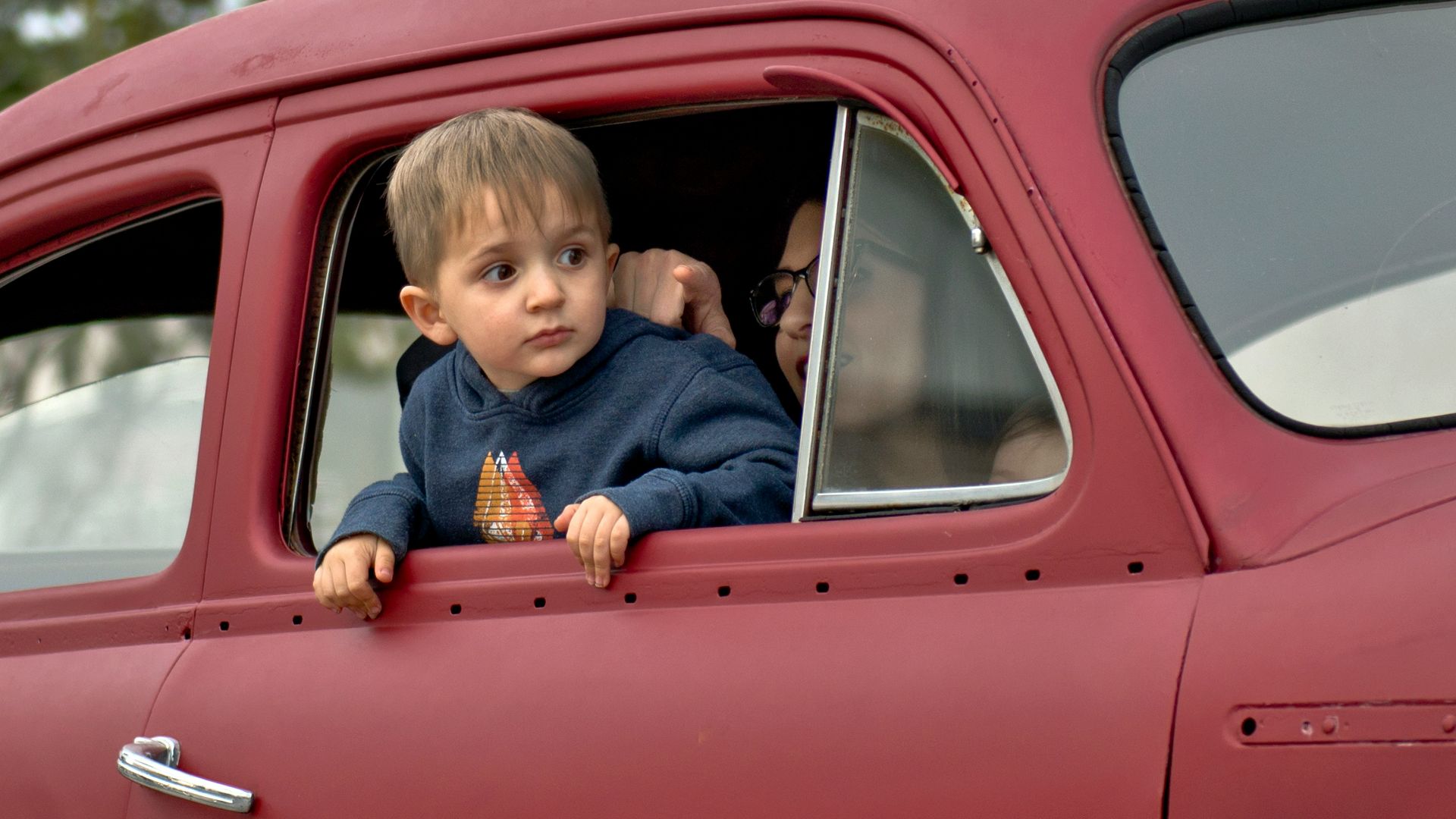 toddler riding on red vehicle