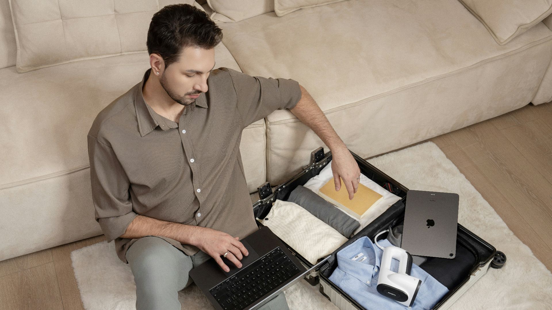 A man sitting on a couch using a laptop computer