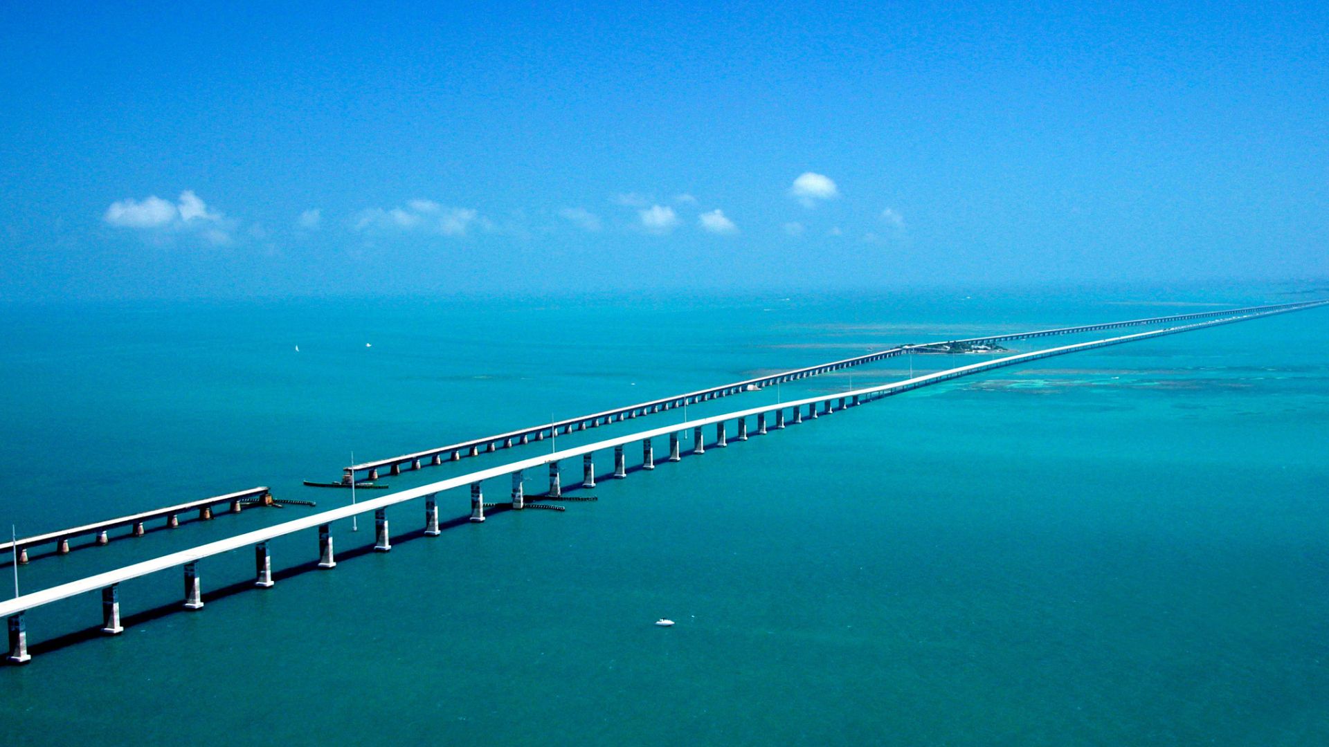Seeming to converge in the distance, the Seven-mile Bridge on the Florida Keys Scenic Highway west of Marathon, FL, runs parallel to the historic Flagler railroad bridge of the early 1900s with the Atlantic Ocean to the South and the Gulf of Mexico to the