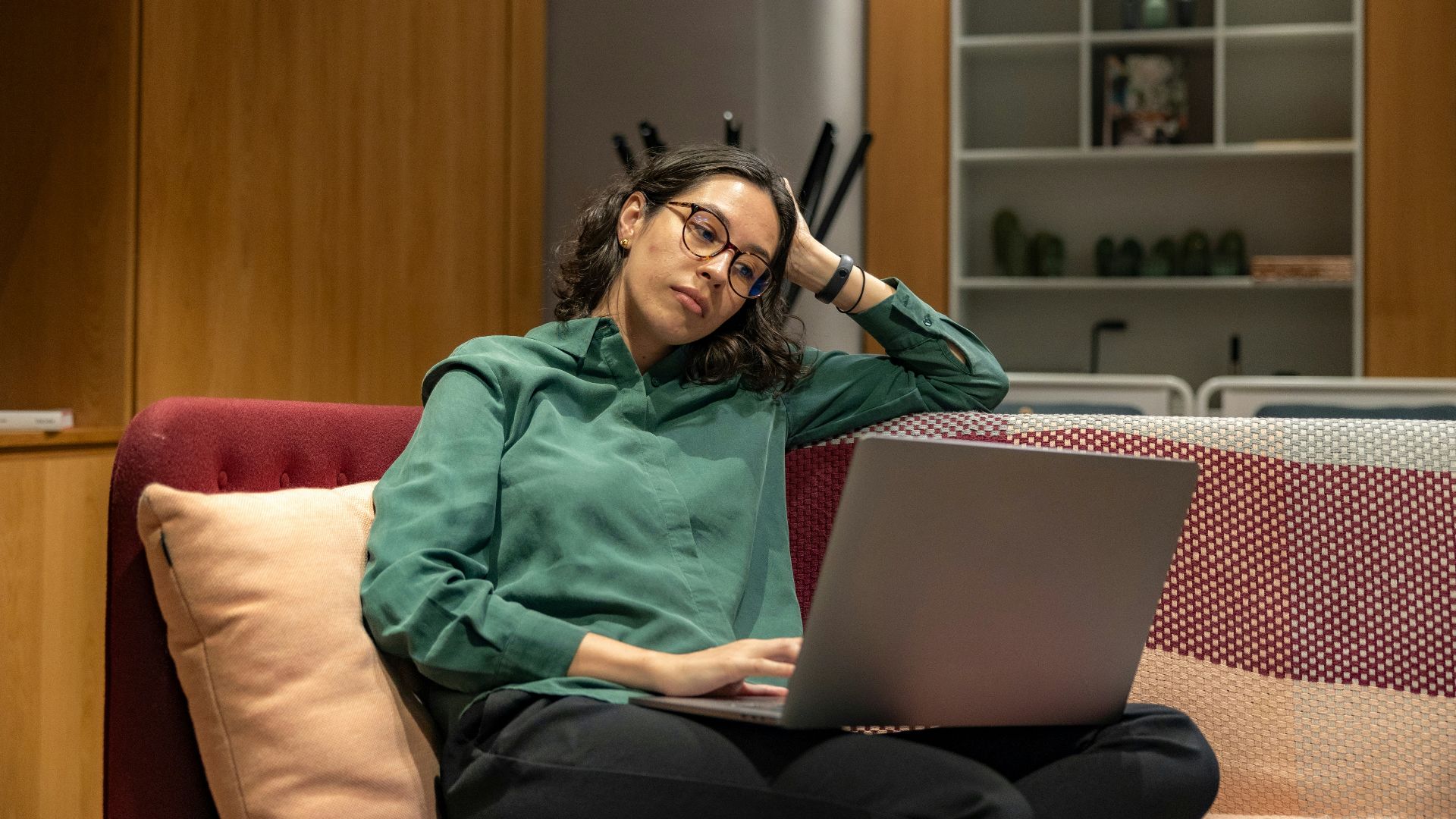a woman sitting on a couch using a laptop computer