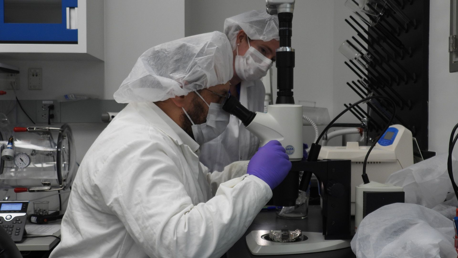 Jason Dworkin, project scientist for NASA's OSIRIS-REx (Origins, Spectral Interpretation, Resource Identification, and Security – Regolith Explorer) mission, examines a portion of the asteroid Bennu sample delivered to Earth in a laboratory at the agency'