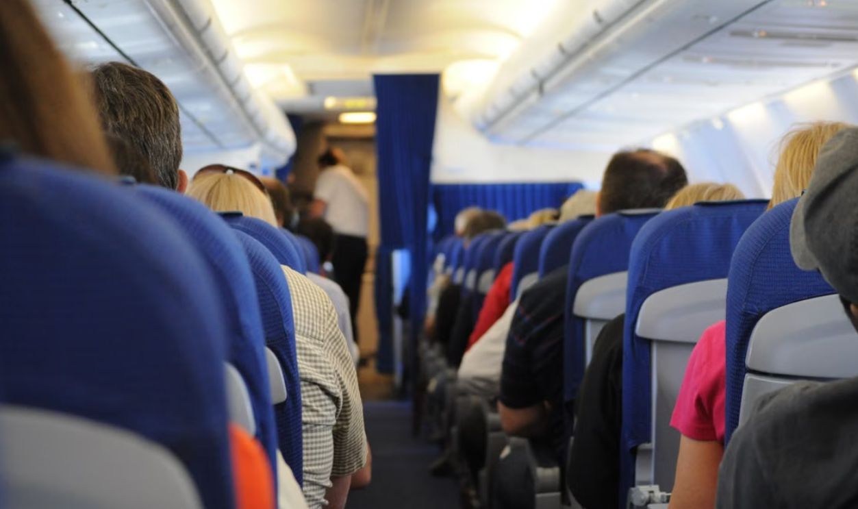 Interior view of an airplane cabin with passengers seated, showcasing air travel experience