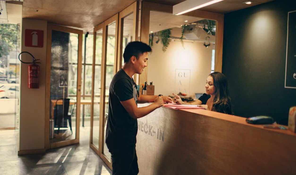 A customer checks in at a hotel reception desk