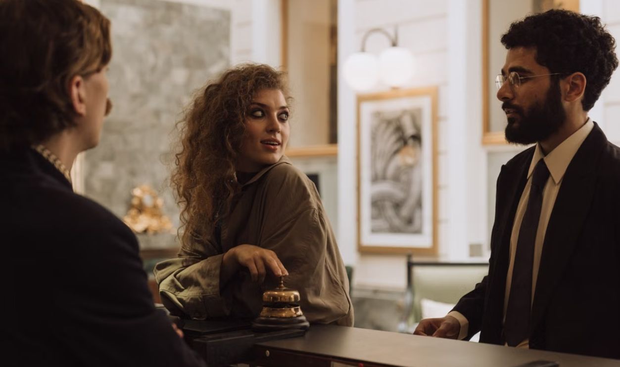 Guests interacting at a luxurious hotel reception desk, emphasizing hospitality and service