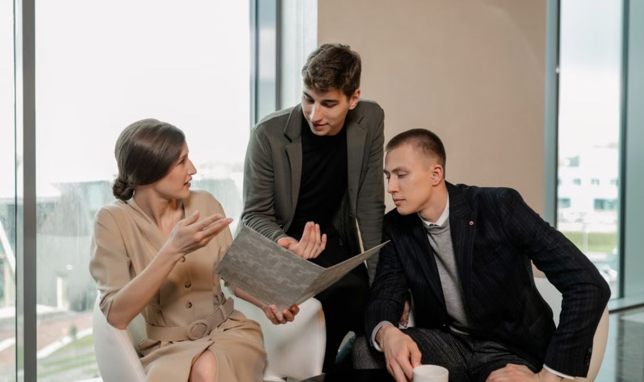 Group of professionals discussing business strategy together inside a modern office.