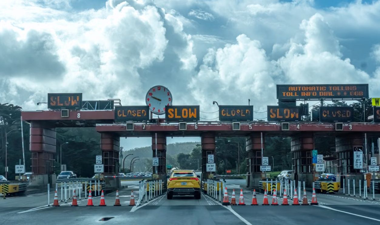View of vehicles approaching the toll plaza at Golden Gate Bridge in San Francisco under a cloudy sky