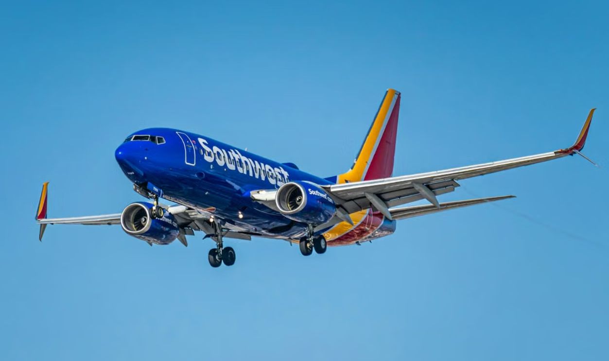 A Southwest Airlines Boeing 737 aircraft flying over Los Angeles, clear blue sky
