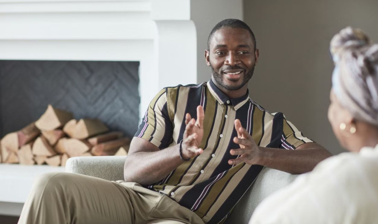 Two adults enjoying a friendly conversation in a cozy modern living room setting
