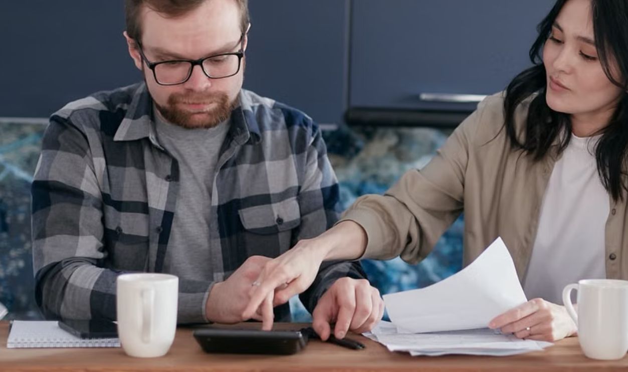 A couple working on their finances together at home, showing teamwork and collaboration