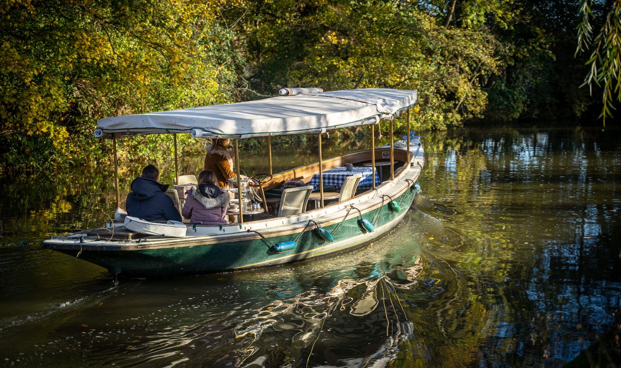 Enjoy a serene boat ride along Oxford's picturesque canal surrounded by autumn foliage