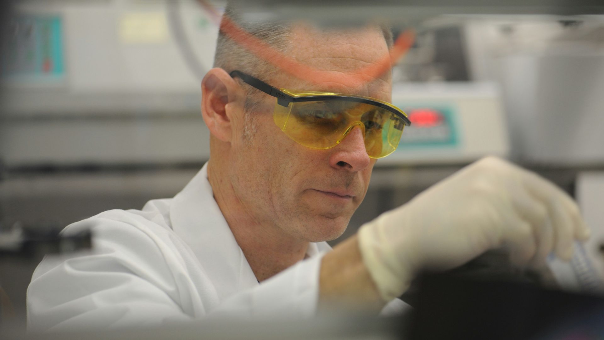 a man in a lab wearing safety goggles