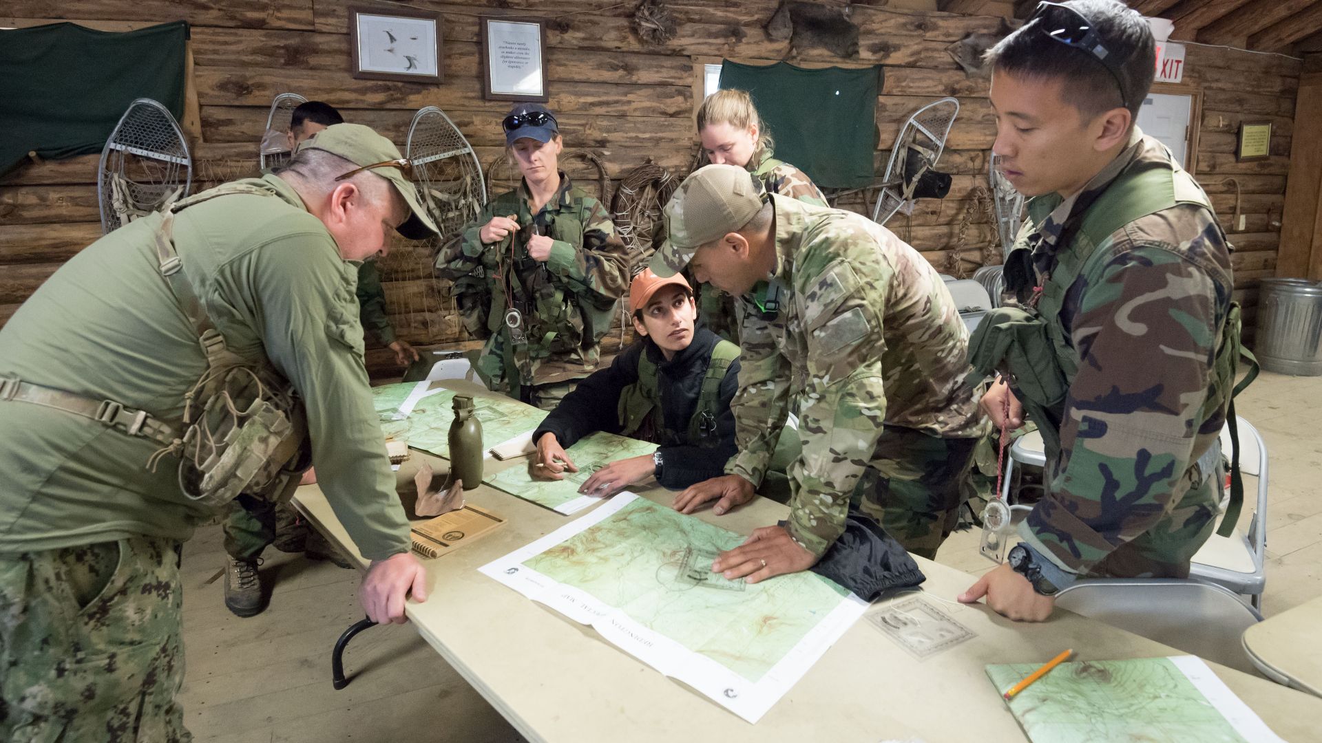 2017 NASA astronaut candidates Jasmin Moghbeli and Frank Rubio discuss their next plan of action while fellow astronaut candidates and their instructor study their topographical maps during wilderness survival training at the U.S. Navy’s Survival, Evasion