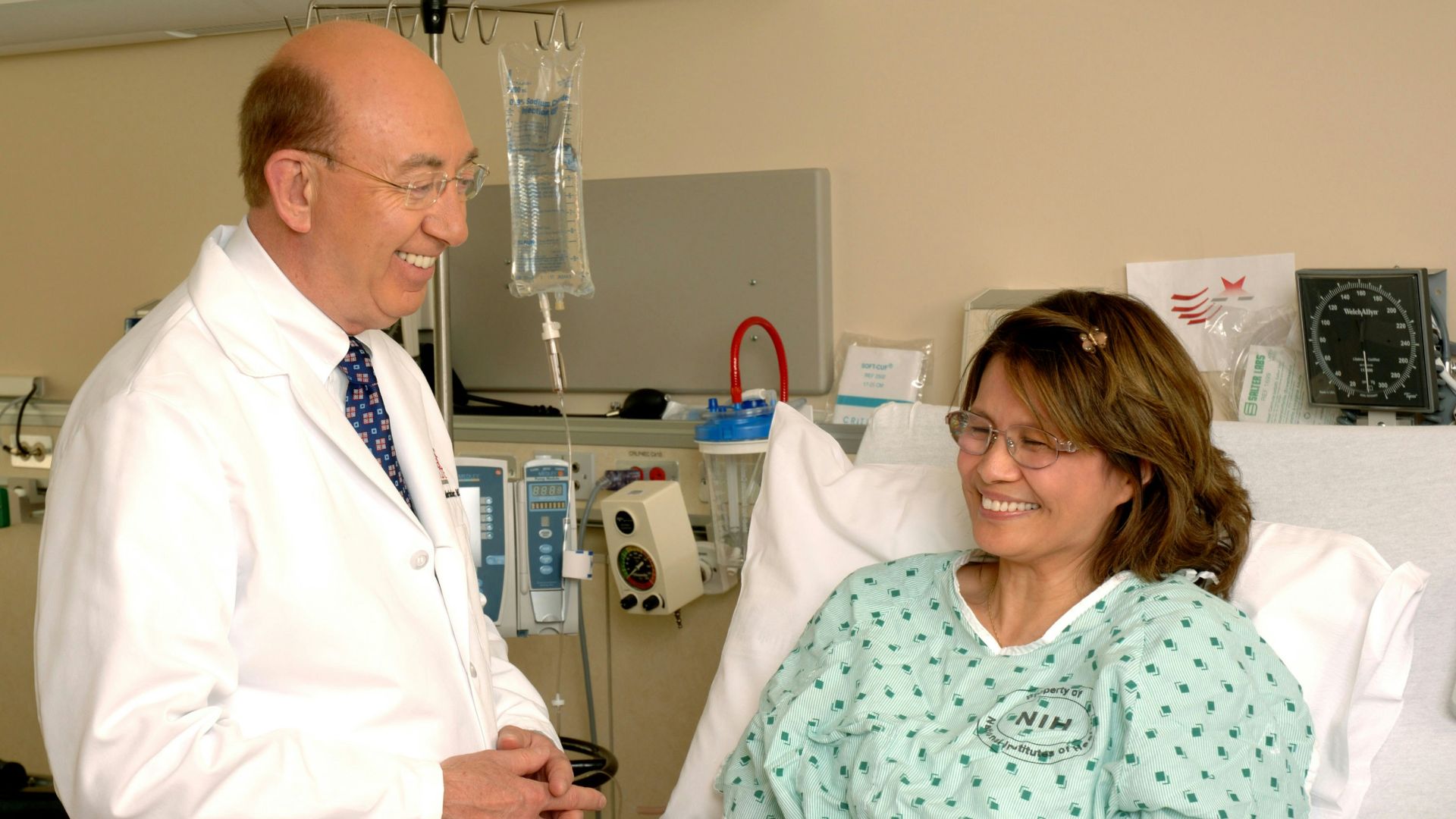 woman in teal scrub suit sitting beside man in white medical scrub suit
