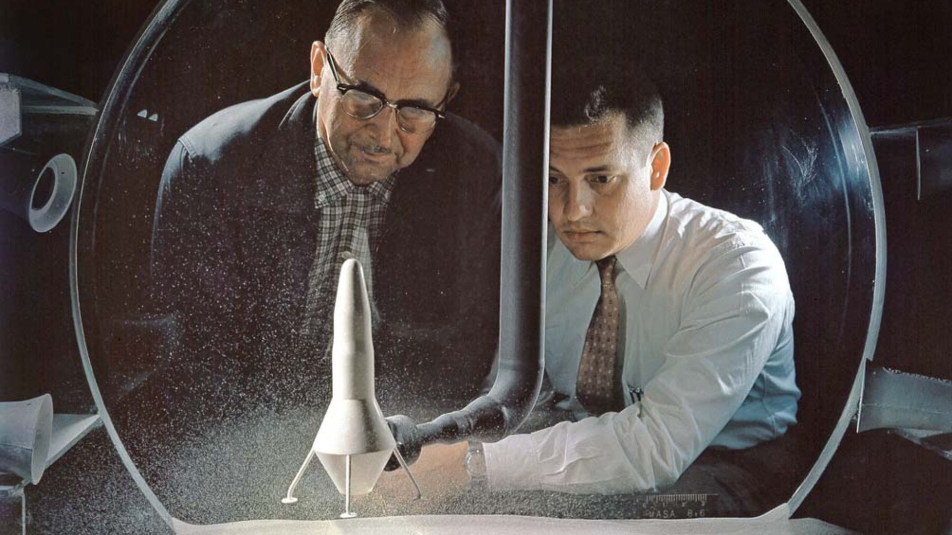 Researchers view a demonstration of the moon dust simulator in the 8- by 6-Foot Supersonic Wind Tunnel facility at the National Aeronautics and Space Administration (NASA) Lewis Research Center. The researchers were studying the effect of the lunar lander