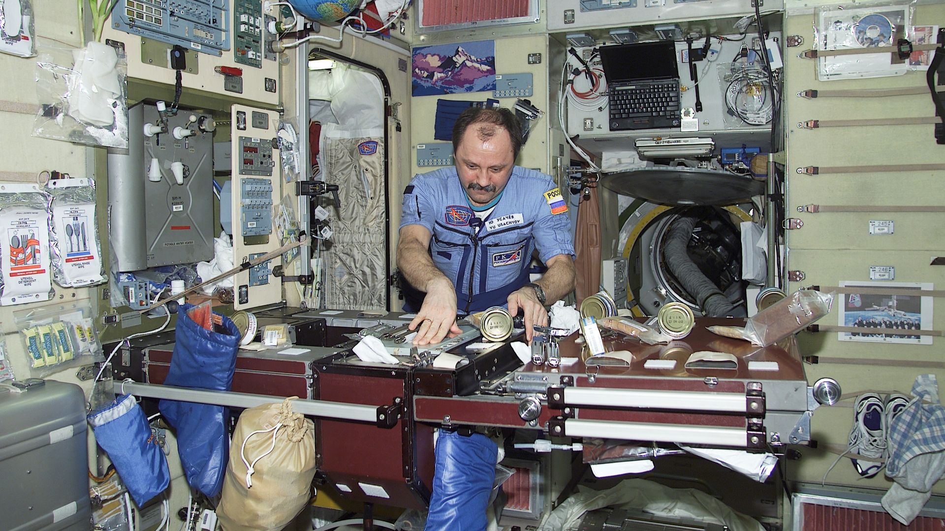 Cosmonaut Yury V. Usachev, Expedition Two commander, organizes different kinds of food in the Zvezda service module aboard the International Space Station (ISS).