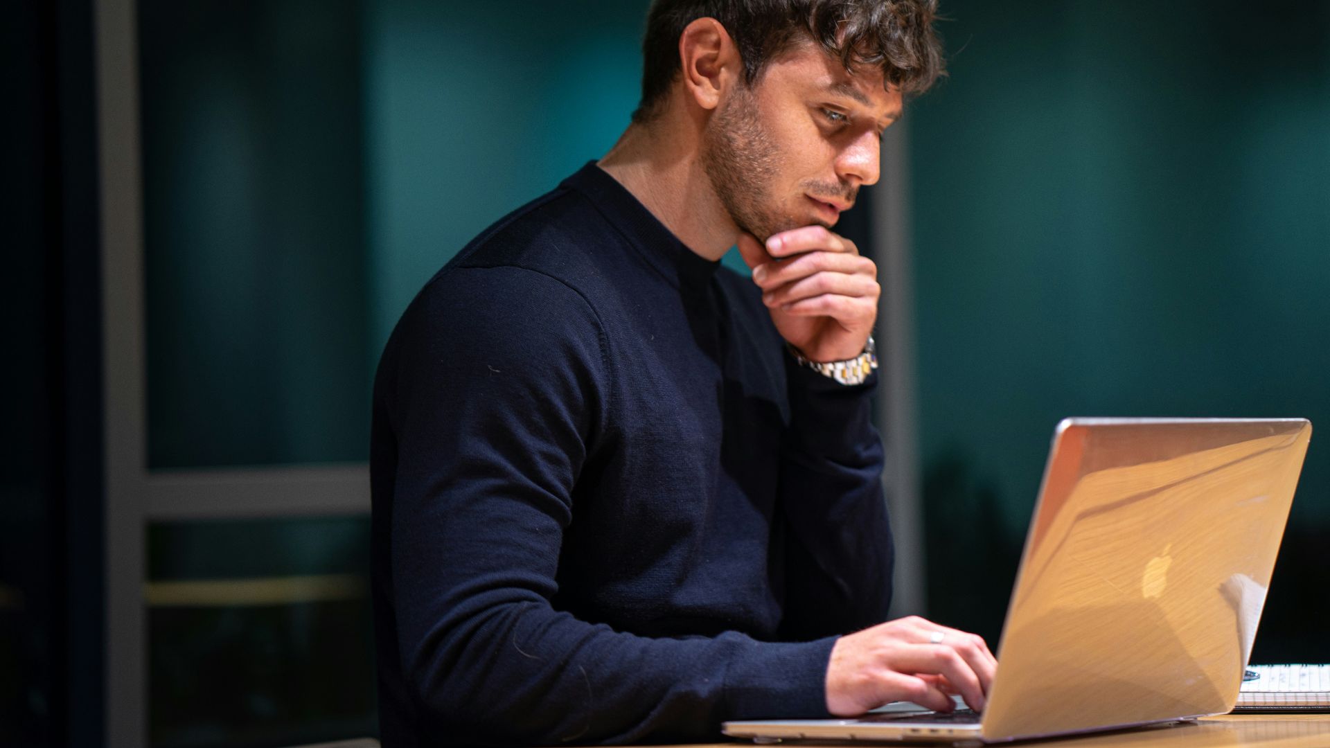 man in black long sleeve shirt sitting in front of macbook