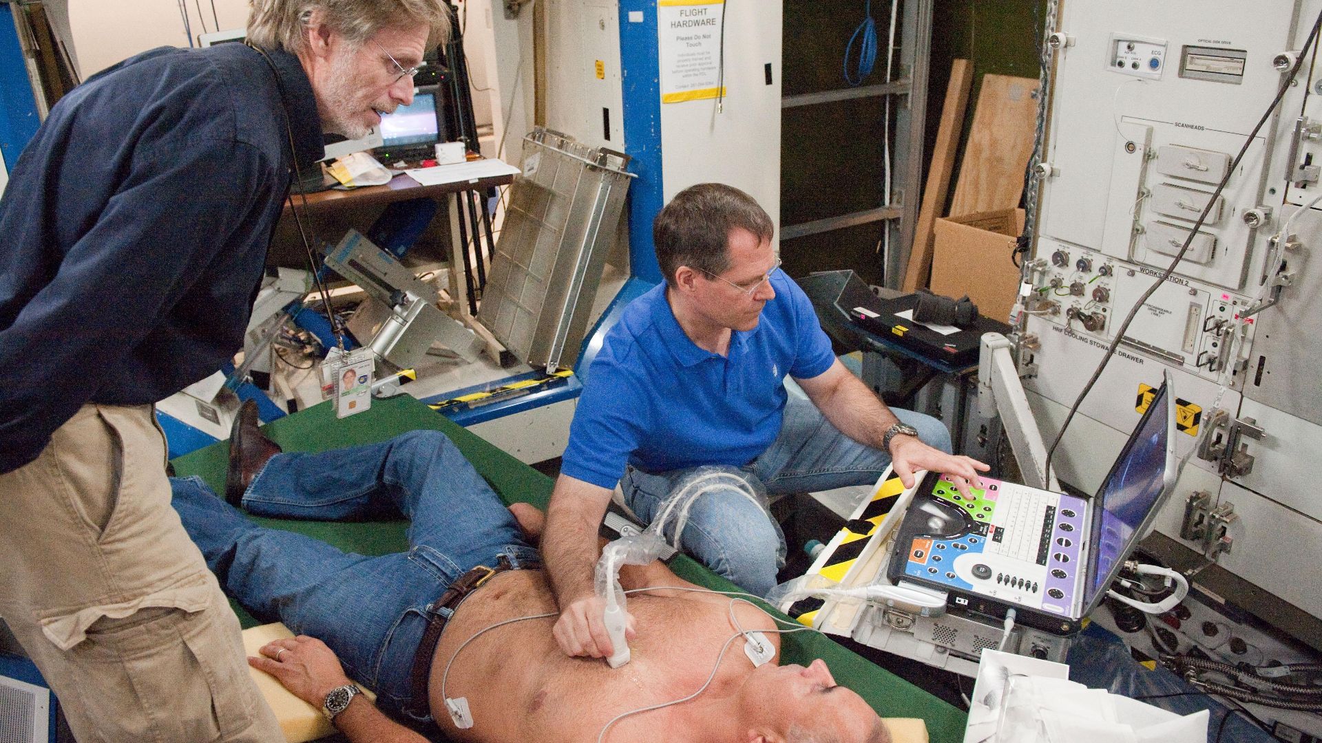 Astronaut Kevin Ford (right) trains with the Ultrasound 2 for the Integrated Cardiovascular experiment. Sonographer David Martin (left) guides the crewmember in obtaining the desired images for the experiment while Ariel Rodriguez (center) serves as the s